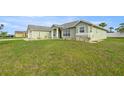 A wide shot showcasing the home's exterior and large front yard with mature landscaping at 9957 Sw 55Th Avenue Rd, Ocala, FL 34476