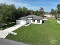 An aerial view shows a modern white home featuring a long driveway and well-maintained green lawn at 11537 Sw 59Th Ter, Ocala, FL 34476