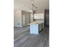 Kitchen with center island, white cabinetry, stainless faucet, and pendant lighting overlooking the living area at 11537 Sw 59Th Ter, Ocala, FL 34476