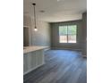 Open-concept living space featuring stylish gray vinyl floors, neutral walls, and a view to the yard at 11537 Sw 59Th Ter, Ocala, FL 34476