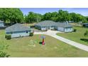 Front exterior of home with green lawn, large driveway and detached garage at 2563 Se 156Th Place Rd, Summerfield, FL 34491