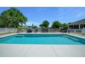 Rectangular pool surrounded by lounge furniture and white picket fence at 2563 Se 156Th Place Rd, Summerfield, FL 34491