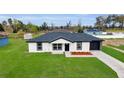 Attractive one-story home with a dark roof, black trim, stone accents, and an expansive green lawn at 1062 Nw 69Th St, Ocala, FL 34474