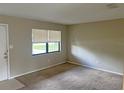 Bright living room featuring a large window and neutral-toned walls and carpet at 1400 Ne 54Th St, Ocala, FL 34479