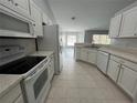 Spacious kitchen features white appliances, modern cabinetry, and tile flooring at 16331 Se 81St Ct, Summerfield, FL 34491