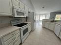 White kitchen features modern appliances, ample cabinet space, and tile flooring at 16331 Se 81St Ct, Summerfield, FL 34491