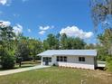 Beautiful shot of a single-story house with a metal roof, tidy lawn, and a newly painted driveway at 23177 Sw Beach Blvd, Dunnellon, FL 34431