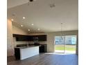 Open-concept kitchen and dining area with modern stainless steel appliances and sliding glass doors at 3474 Sw 155Th Pl, Ocala, FL 34473