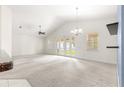 Open living room featuring a vaulted ceiling, neutral carpet, and sliding doors to the outdoors at 4780 Sw 103Rd Street Rd, Ocala, FL 34476