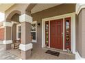 Inviting front porch with brick pavers, decorative columns, and comfortable seating creating a welcoming entrance at 5026 Sw 128Th St, Ocala, FL 34473