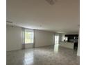 Bright and open living room with tile floors, large windows, and access to the kitchen at 593 Marion Oaks Trl, Ocala, FL 34473