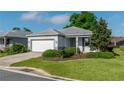 Charming single-story home featuring a manicured front yard, gray exterior paint, and a two-car garage at 8546 Sw 79Th Ave, Ocala, FL 34476