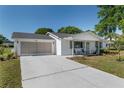 Well-maintained single-story home featuring a screened two-car garage and a cozy front porch at 8851 Sw 116Th Street Rd, Ocala, FL 34481