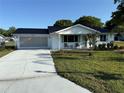 Charming single-story home with a well-manicured lawn, light-colored driveway, and two-car garage at 8851 Sw 116Th Street Rd, Ocala, FL 34481