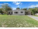 Exterior view of house featuring a carport, well-kept lawn, and neutral-toned siding at 8954 Sw 104Th Ln, Ocala, FL 34481