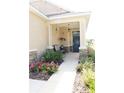 Inviting front porch area, featuring stone accents, decorative plants, seating, and a stylish front door at 9764 Sw 100Th Avenue Rd, Ocala, FL 34481
