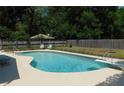 A sparkling in-ground pool with diving board surrounded by a large patio and lush greenery at 1069 Se 57Th Ave, Ocala, FL 34480