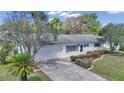 Charming home featuring blue shutters, a well-manicured lawn, mature landscaping, and an attached two-car garage at 11118 Sw 76Th Ave, Ocala, FL 34476