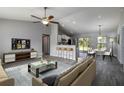 Open-concept living space with vaulted ceilings, fan, and seamless flow to the kitchen and dining area at 11887 Se 71St Ave, Belleview, FL 34420