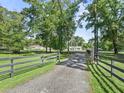View of a home with a long driveway, mature trees, and well-maintained landscaping at 13897 W Highway 328, Ocala, FL 34482