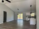 Spacious living room with vaulted ceiling, modern lighting fixtures, and sliding glass doors to the backyard at 20652 Sw Cardinal Ave, Dunnellon, FL 34431