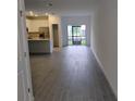 Open-concept living room with wood-look tile floors, and sliding glass doors to outdoor at 3571 Se 37Th Ct, Ocala, FL 34480
