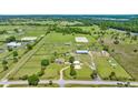 Wide aerial shot showcasing a meticulously laid out horse farm, complete with paddocks, training facilities, and a well-maintained property at 5415 Nw 100Th St, Ocala, FL 34482