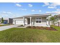 Well-maintained single-story home with a two-car garage, covered porch, and lush green lawn on a sunny day at 5714 Sw 75Th Ave, Ocala, FL 34474