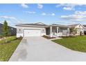 Inviting single-story home featuring a two-car garage, cozy covered porch, and a beautifully landscaped front yard at 5714 Sw 75Th Ave, Ocala, FL 34474