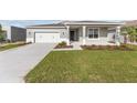 Attractive single-story home boasting a two-car garage, inviting covered porch, and a verdant lawn at 5714 Sw 75Th Ave, Ocala, FL 34474