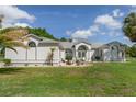 Charming one-story home with manicured front yard, mature palm trees, and a welcoming front entrance with arched windows at 5819 Ne 72Nd St, Silver Springs, FL 34488