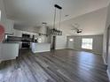 Open-concept living space with modern gray floors, white cabinets, granite counters and plenty of natural light at 6101 Sw 206Th Ave, Dunnellon, FL 34431