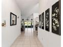 Bright hallway with tile flooring, decorative wall art, and views of the living area and outdoor space at 680 Farmington Ave, The Villages, FL 32162