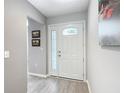 Welcoming entryway with neutral walls, wood-look flooring, and a stylish front door at 7474 Se 172Nd Fieldcrest St, The Villages, FL 32162