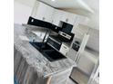 Kitchen featuring granite countertop, stainless steel appliances, and modern fixtures at 9247 Se 142Nd Pl, Summerfield, FL 34491