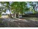 A view of the backyard of a modest home with a side yard with a grassy area and trees at 935 Ne Sanchez Ave, Ocala, FL 34470