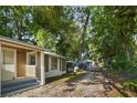 A view of the side of a modest home with light brown siding and a glimpse of a driveway at 935 Ne Sanchez Ave, Ocala, FL 34470