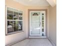 Welcoming front entrance featuring a storm door, a window, and a neutral color scheme at 9541 Sw 93Rd Loop, Ocala, FL 34481