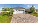 Spacious two-car garage with brick paver driveway and manicured lawn at 9697 Sw 102Nd Ter, Ocala, FL 34481