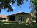The back of a tan house with lots of big arched windows, with a blue sky overhead at 10918 Sw 71St Cir, Ocala, FL 34476