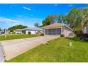 Exterior shot of a well maintained home with a two-car garage, driveway, and lush front lawn at 11058 Sw 69Th Cir, Ocala, FL 34476