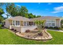 Front yard featuring lush lawn, flower beds and manicured shrubs adding to the home's curb appeal at 11058 Sw 69Th Cir, Ocala, FL 34476