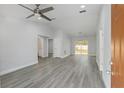 Spacious living room featuring vaulted ceilings, gray flooring, neutral paint, and sliding glass doors at 13300 Sw 105Th Pl, Dunnellon, FL 34432