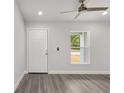 Bright room with neutral paint, a ceiling fan, gray flooring, a window and a white door at 13300 Sw 105Th Pl, Dunnellon, FL 34432