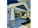 Inviting covered front porch with stone supports and colorful landscaping at 13518 Sw 114Th Ln, Dunnellon, FL 34432