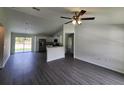 Spacious living room featuring gray floors, white walls and an open floorplan to the kitchen at 1475 Sw Big Bear Rdg, Dunnellon, FL 34431