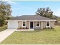 Beautifully landscaped home with a spacious front yard, attached garage, and neutral-toned exterior at 15067 Sw 16 Pl, Ocala, FL 34481