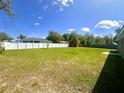 Spacious backyard featuring a well-maintained lawn and a sturdy white fence, perfect for outdoor activities at 15585 Sw 46Th Cir, Ocala, FL 34473
