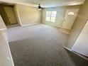Bright living room featuring neutral carpet, a ceiling fan, and a front entrance with natural lighting at 15585 Sw 46Th Cir, Ocala, FL 34473