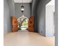 Elegant foyer with arched doorway, custom wooden doors, and a view of the home's exterior at 1718 Sw 27Th St, Ocala, FL 34471